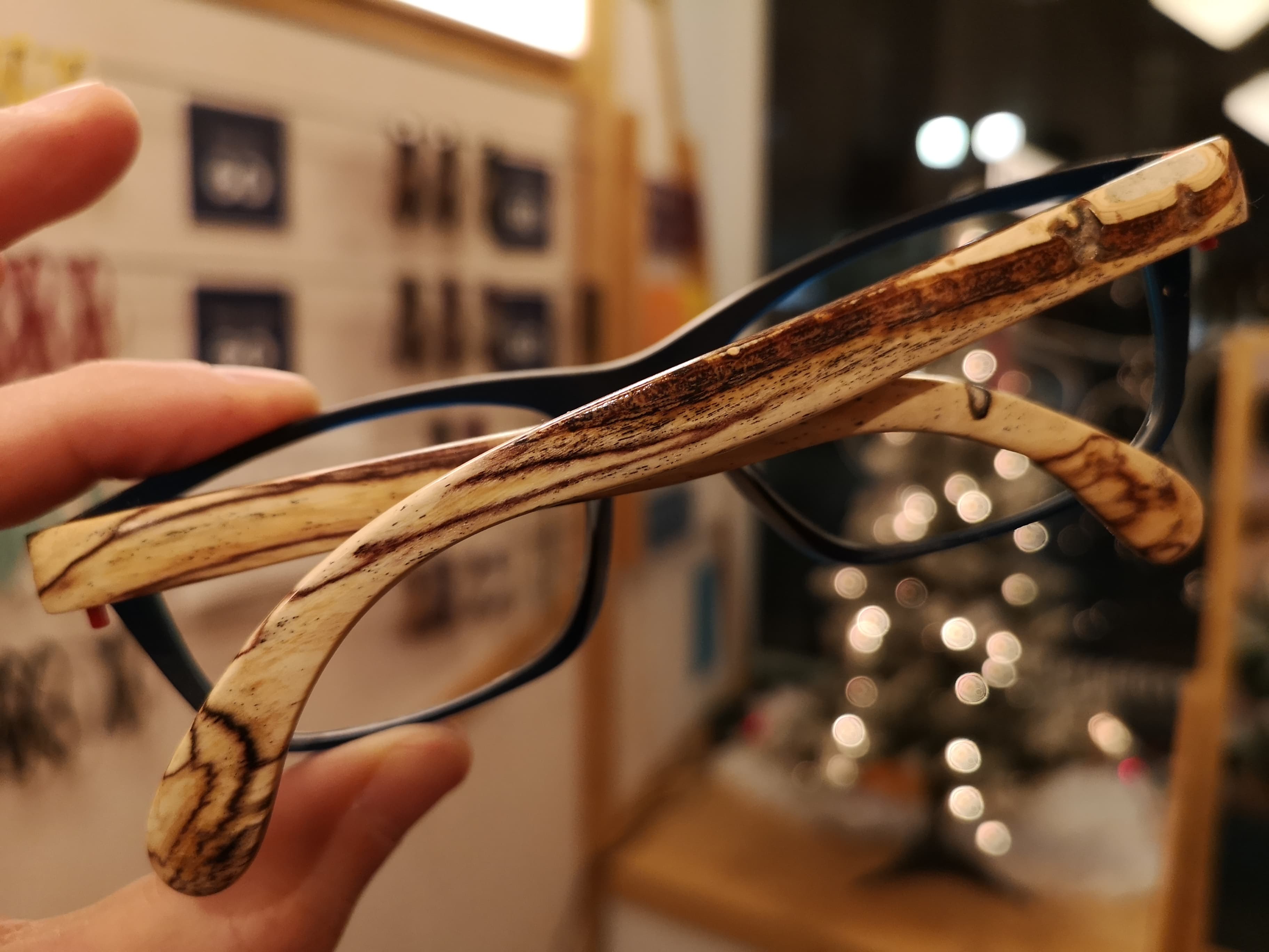 Midnight blue eyeglasses with spalted maple temples showing dramatic dark streaks in the wood grain